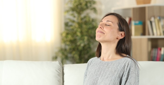 woman breathing deeply in home